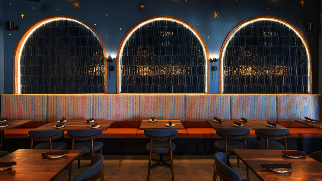 Illuminated arched wall features and booth seating inside La Loba restaurant